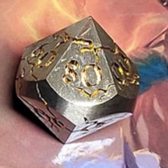 D% — Percentile die, full scale: a brushed silver metal ten-sided percentile die with gold engraving, sitting on its 80 face, cropped from the set photo