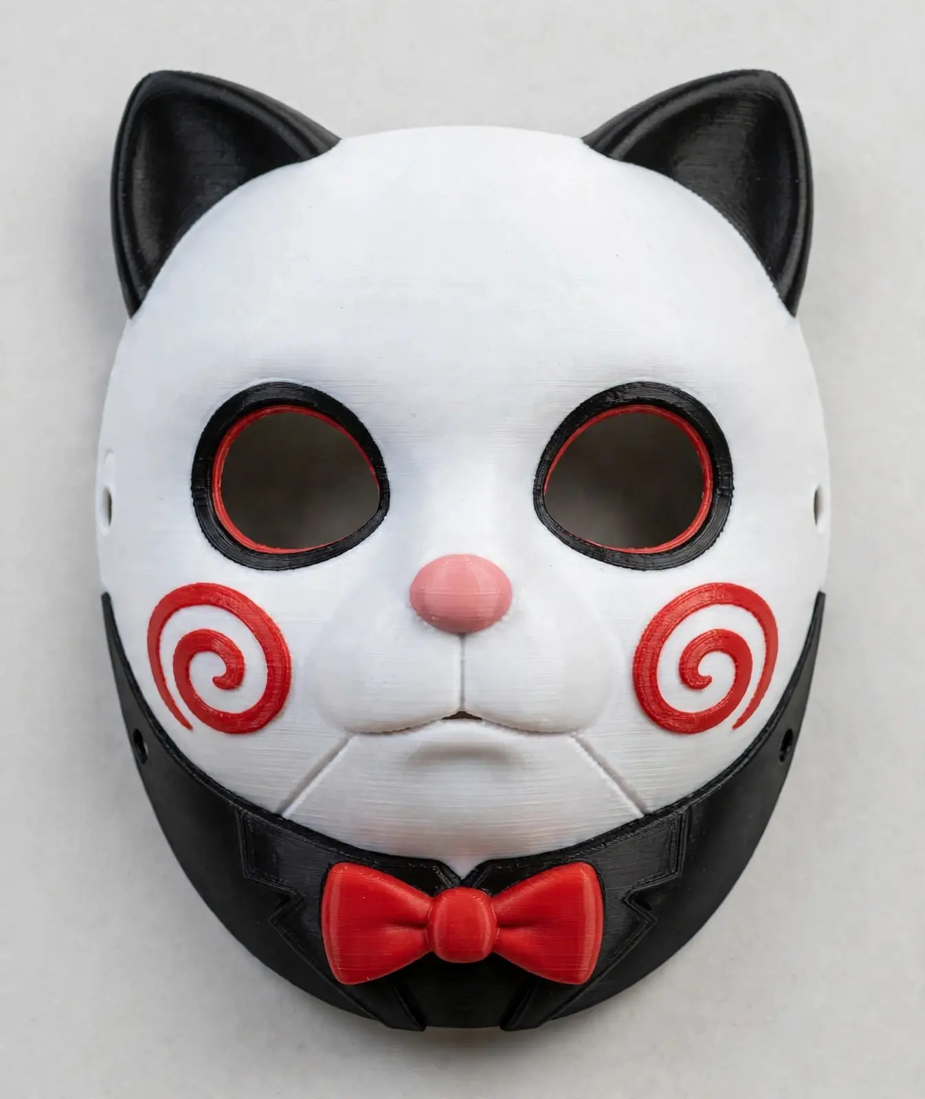 Puppet Cat mask — white cat mask with black ears, hollow black-and-red eyes, pink nose, red spiral cheek relief and a red bow at the chin